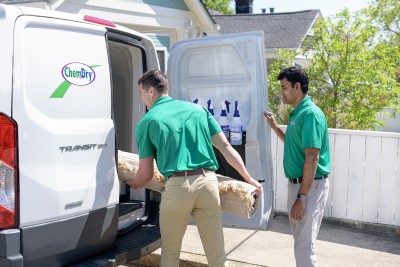 Technicians loading area rug into van